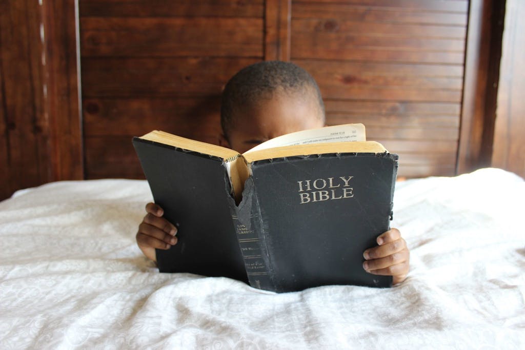 Photo of Child Reading Holy Bible. Grow in walk with Christ.