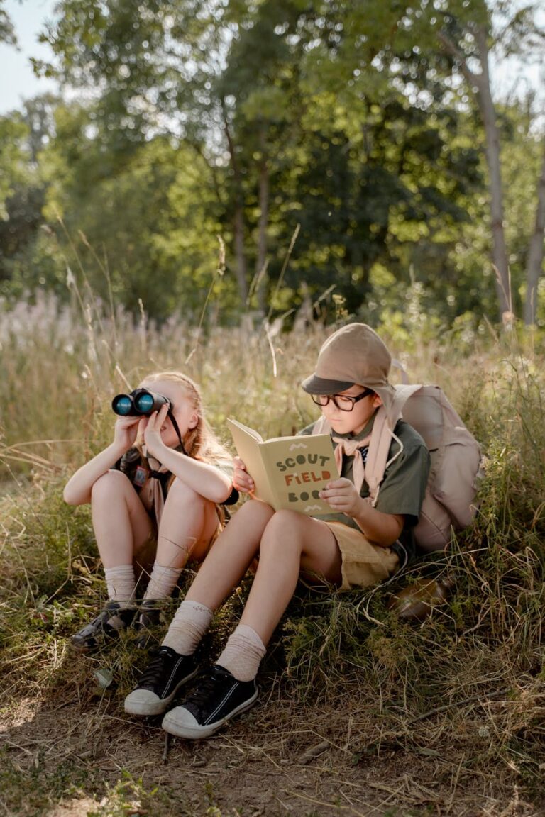 a girl and boy sitting on the grass together