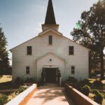 two person standing near white church