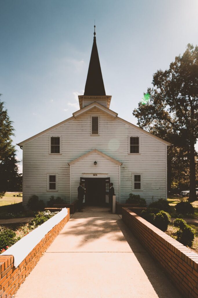 two person standing near white church